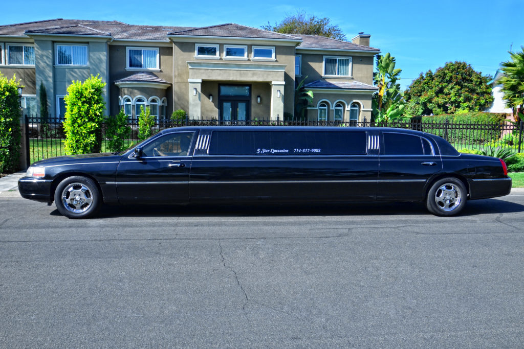 stretch black limousine in from of a house